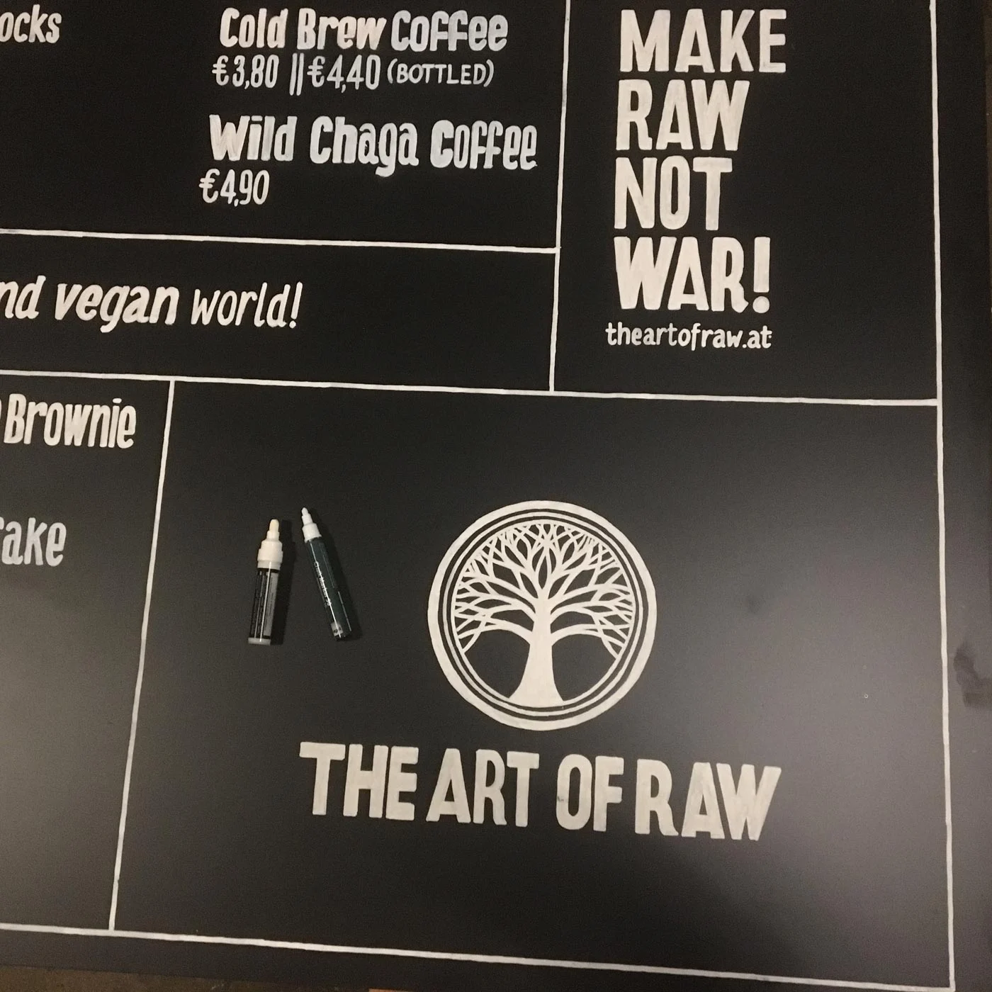 Logo und handgeschriebene Menüpunkte auf einer großformatigen Kreidetafel für The Art of Raw