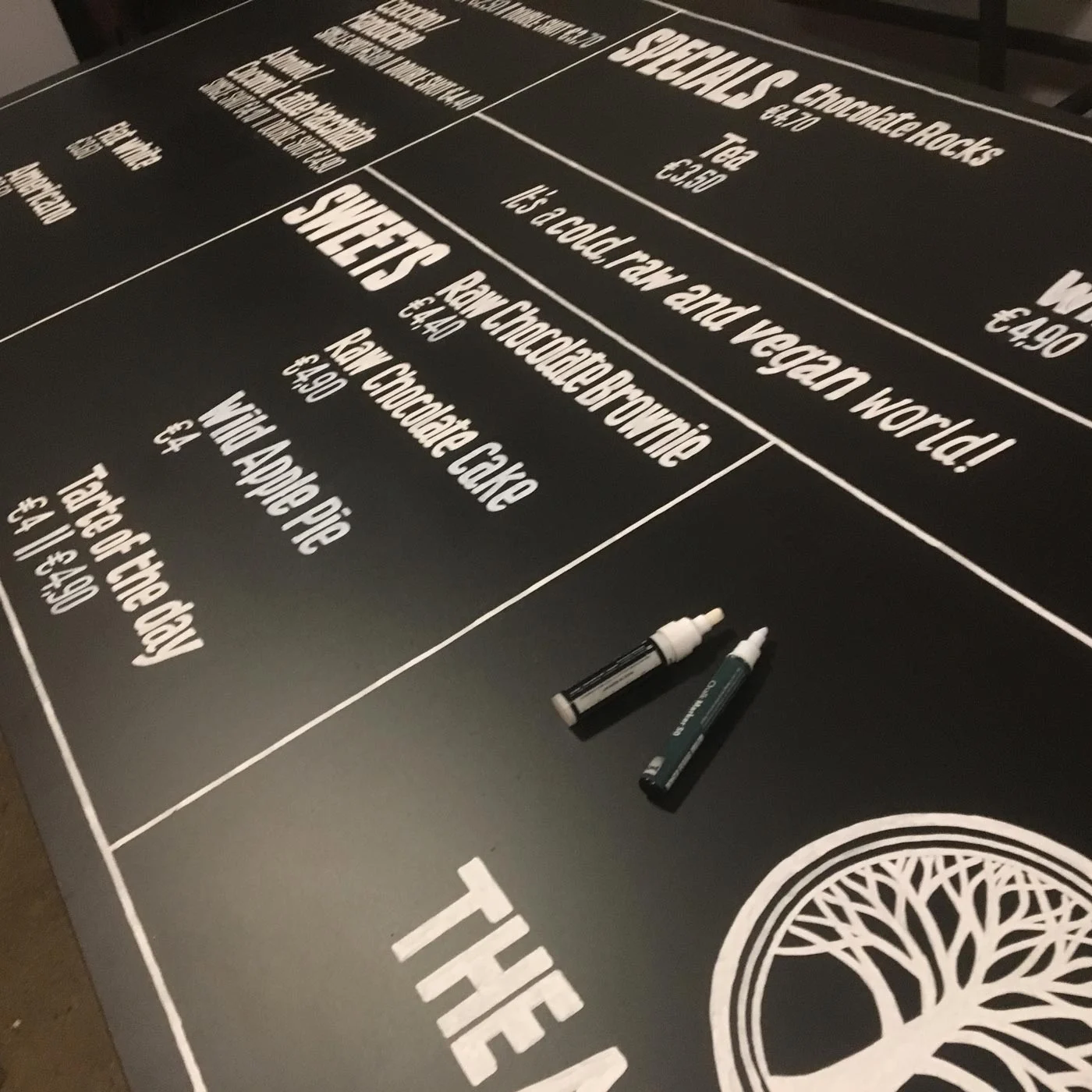 Nahaufnahme von Logo, Linien und Menütexten der The Art of Raw Kreidetafel