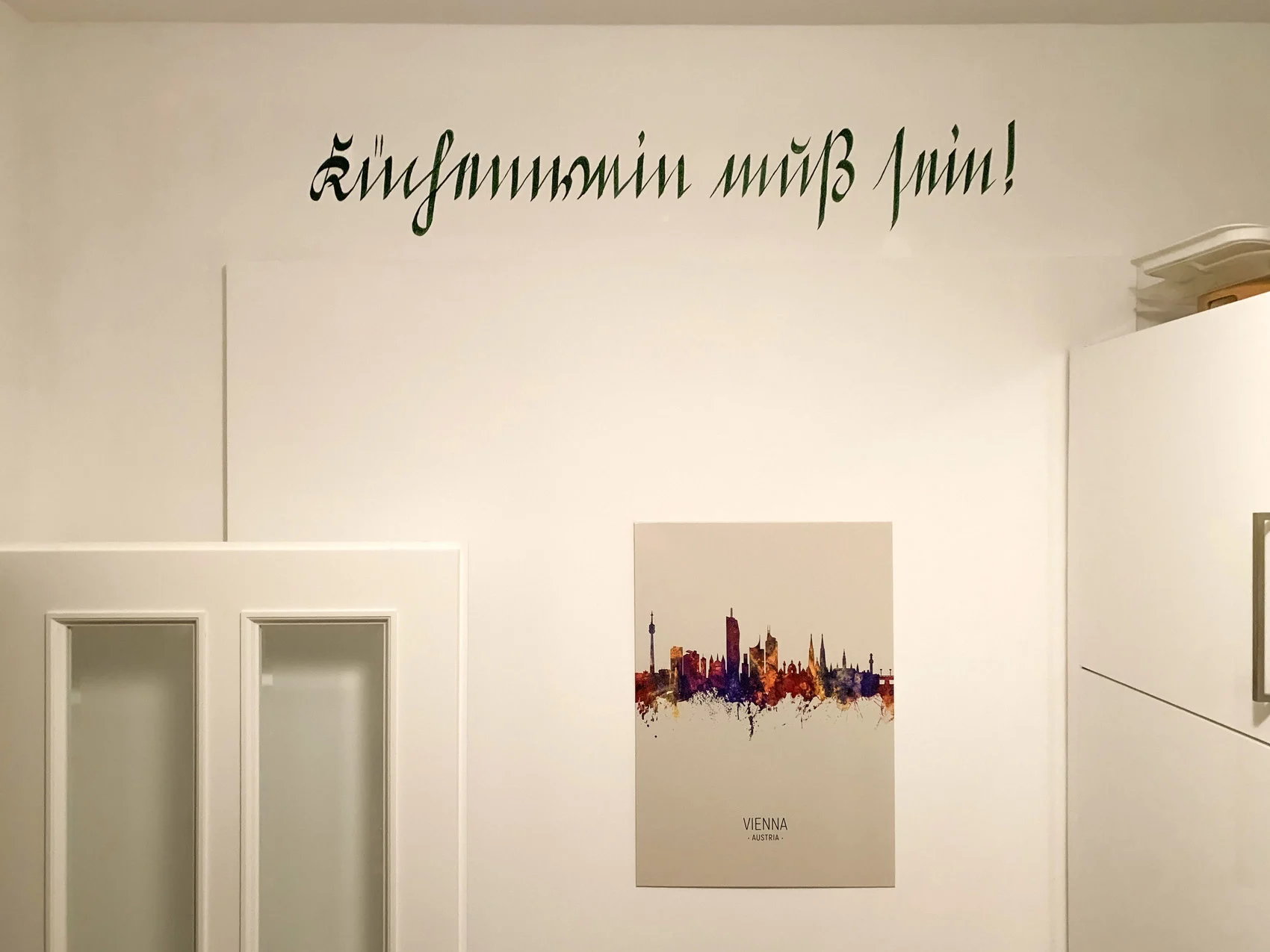Küchenwand mit dem handgemalten Kurrentschriftzug Küchenwein muss sein