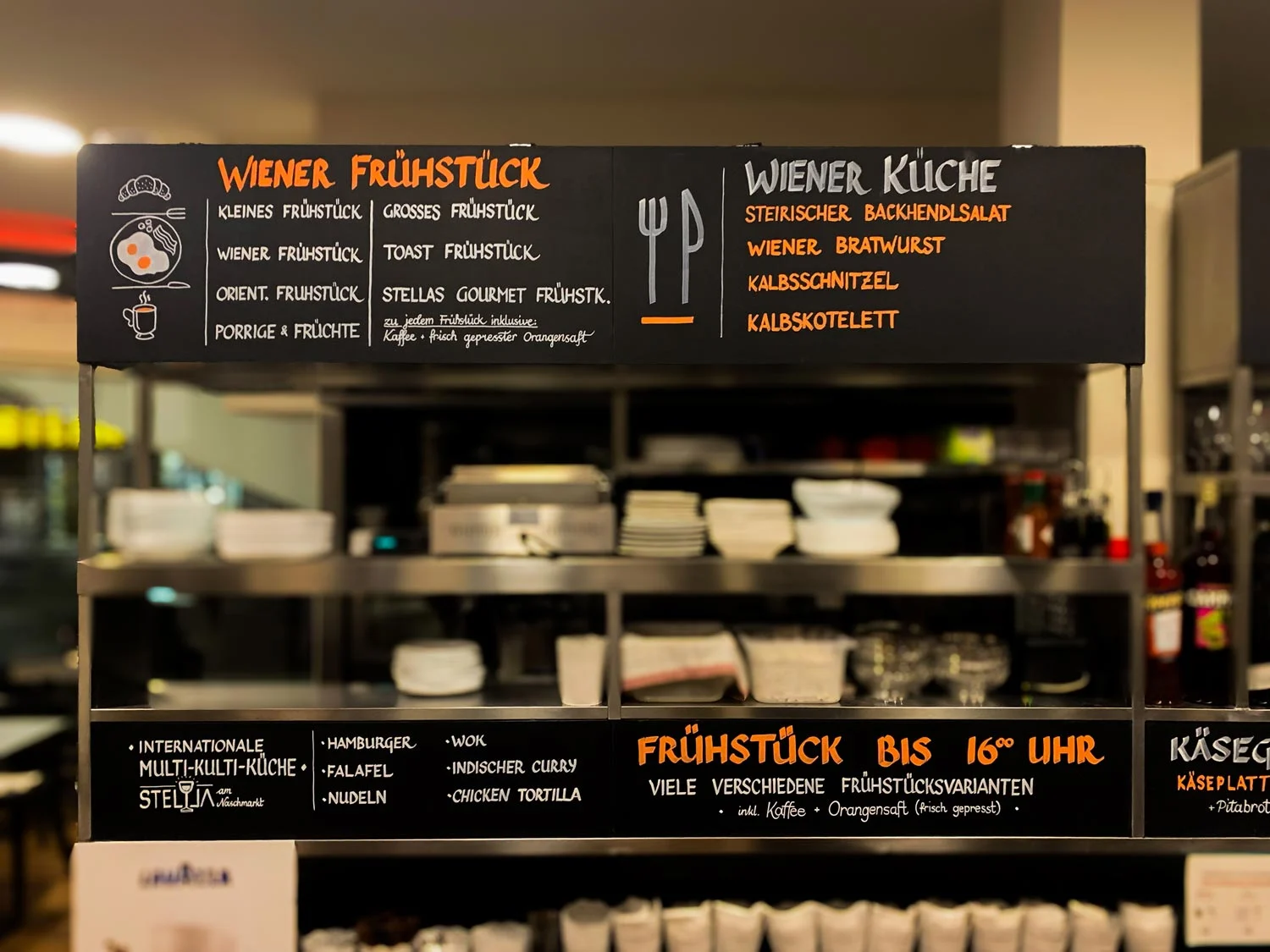 Übersicht eines umfangreichen handbeschrifteten Menüsystems über einer offenen Küche